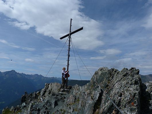 Nils am Gipfelkreuz vom Auernig. Im Hintergrund die Kreuzeckgruppe.