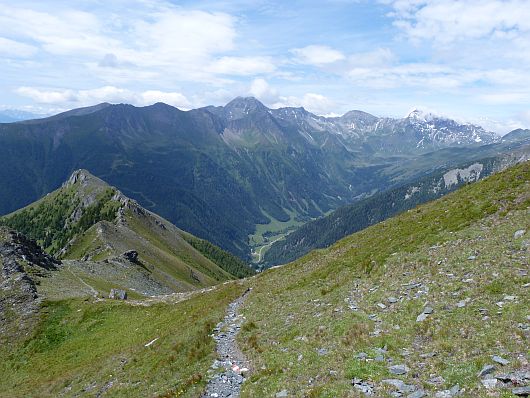 In der ersten Steilstufe wurde schon deutlich an Höhe gewonnen. Der Auernig ist ganz links zu sehen. Im Hintergrund das Tauerntal mit Goldberggruppe.