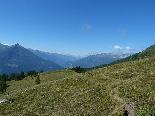 Eine Almfläche wurde hier durchlaufen. Links die Berge der Kreuzeckgruppe, rechts die Goldberggruppe und am Horizont die Lienzer Dolomiten.