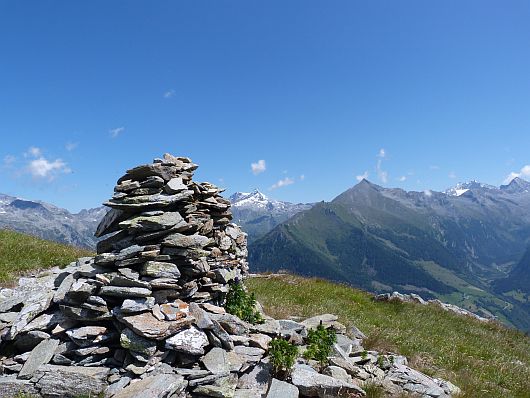 Steinmanderl auf der Lassacher Höhe. Links davon schließen sich an: Ankogel, Maresenspitze, Hochalmspitze und Säuleck.